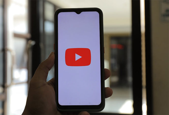 holding-up-smartphone-with-youtube-icon-on-it