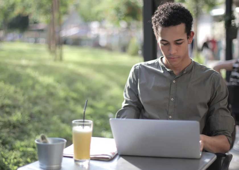 man working on laptop at park