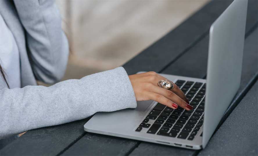 woman typing checkmark on laptop